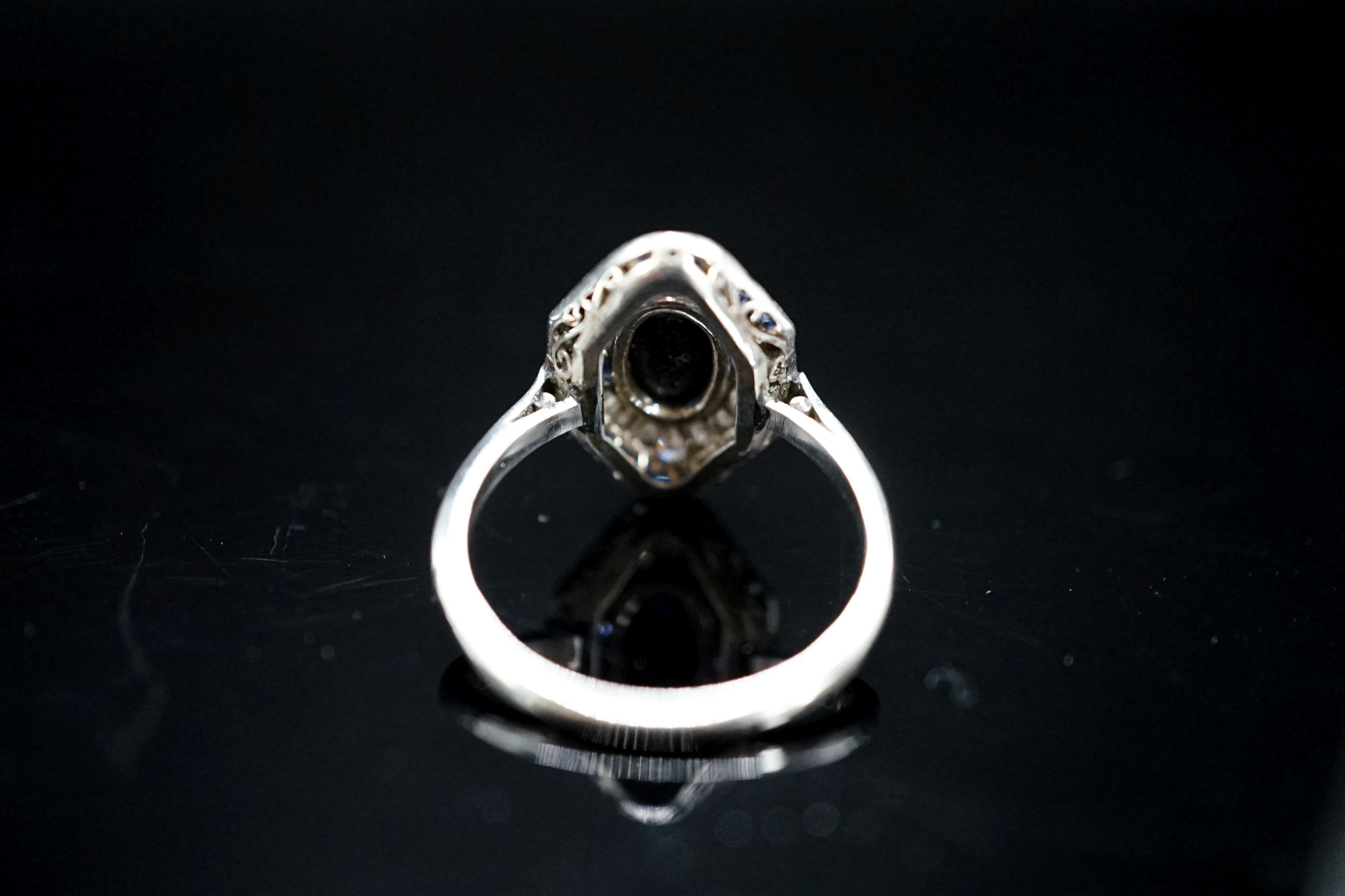 A 1920's white metal (stamped plat), sapphire and diamond ring, with central cabochon sapphire, size M, gross weight 4.6 grams.